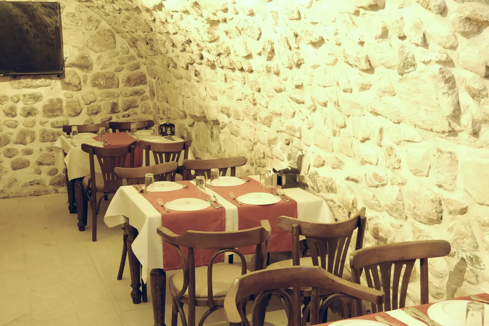 Taş tonozlu restoran salonunda kurulmuş masalar